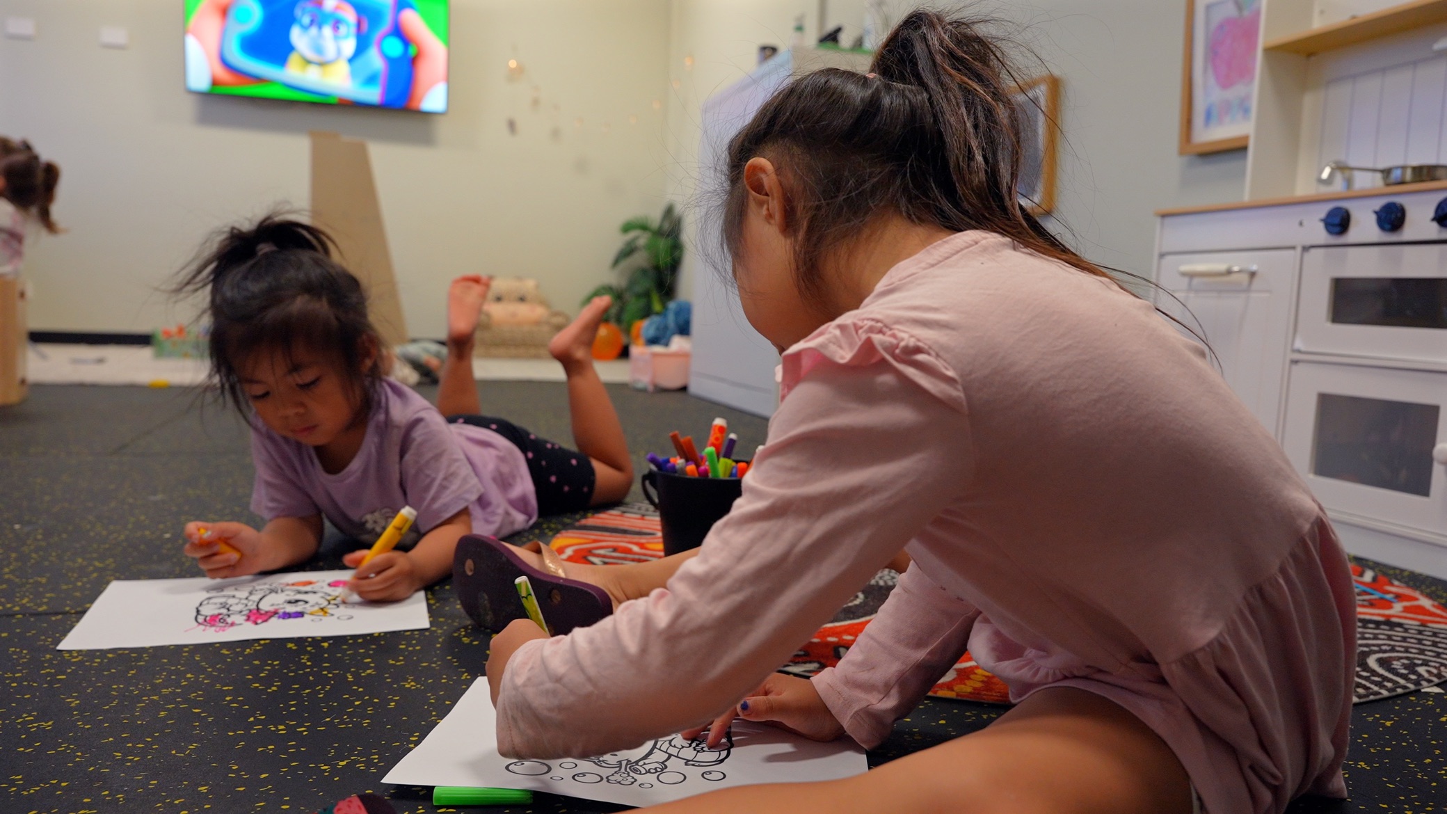 Children colouring and playing in the supervised crèche at Athletic Gym